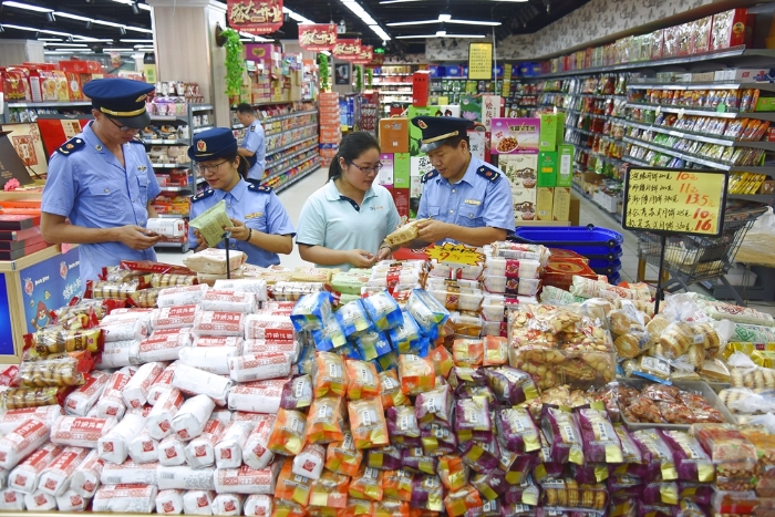图为东海县市场监管局黄川分局执法人员正在超市检查月饼的质量。