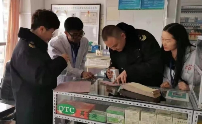 执法人员正在检查药店药品销售记录情况。阿拉善盟市场监督管理局供图。