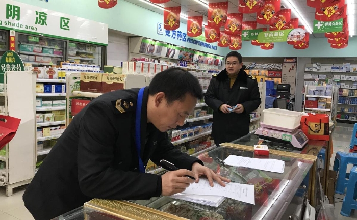 图为市场监管执法人员在贵州一树民生药业连锁有限公司铜仁市火车站分店进行安全检查。