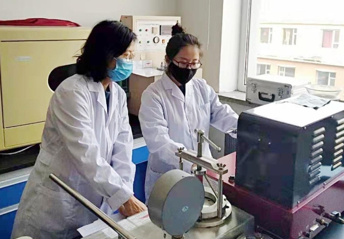 图为吉林省器械所检验人员进行医用一次性口罩的项目检验。