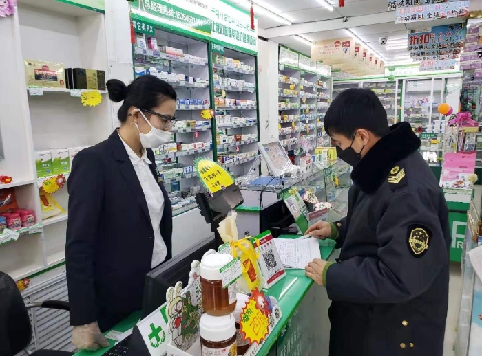 图为执法人员在一家药店检查。