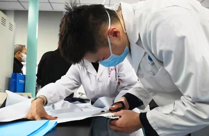 陕西省医疗器械质量监督检验院工作人员正在对防护用品材料进行检测。