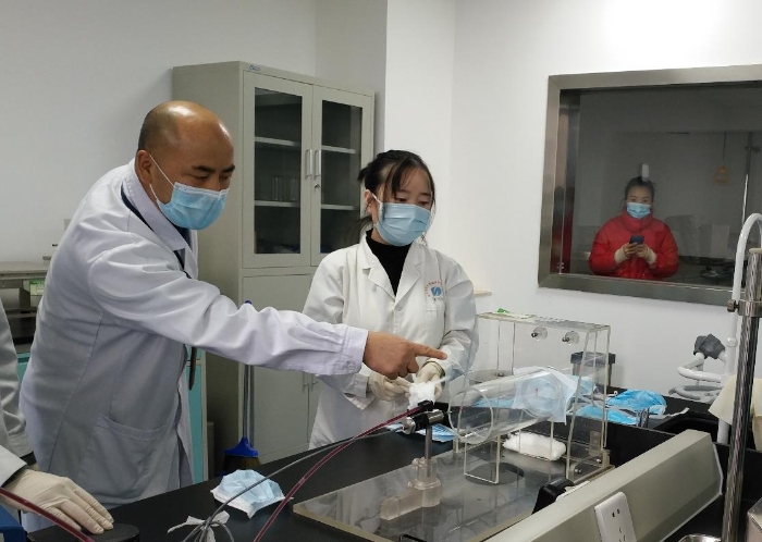 陕西省医疗器械质量监督检验院工作人员正在对医用口罩进行质量检测。