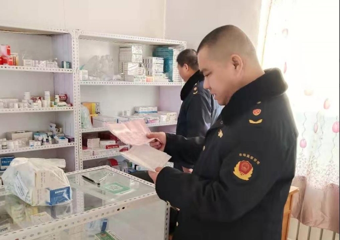 图为乾安县市场监管局农村基层所执法人员检查村中药店药品质量及售价。