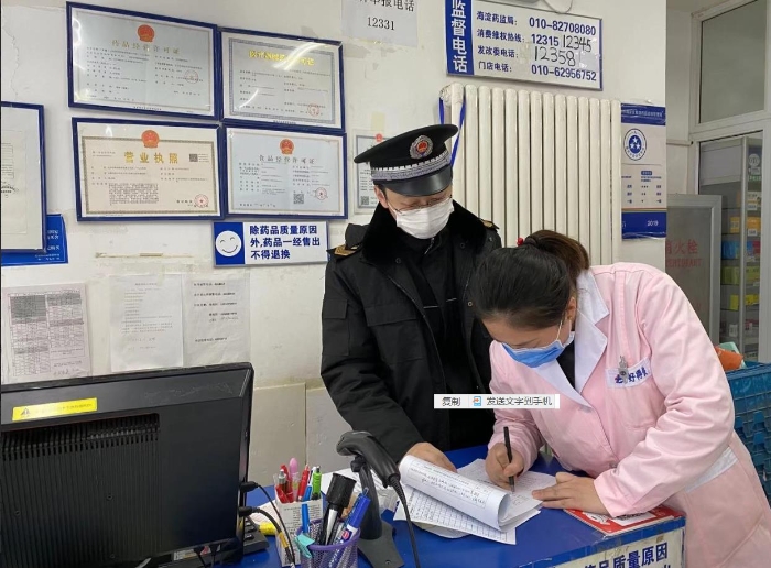 疫情防控期间，海淀区市场监管局执法人员在一家药店检查。（海淀区市场监管局供图）