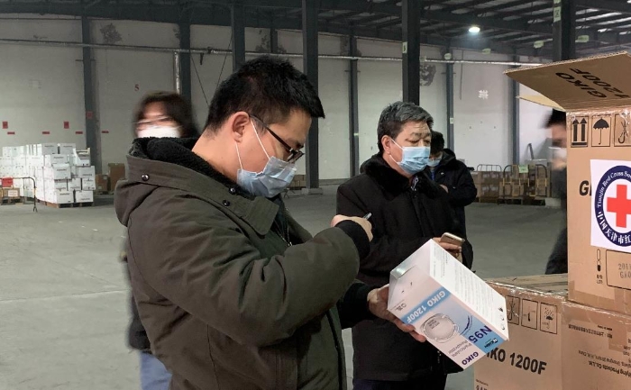 图为天津市药品监督管理局驻某防疫物资库质量查验小组对医用防护口罩等进行严格查验。