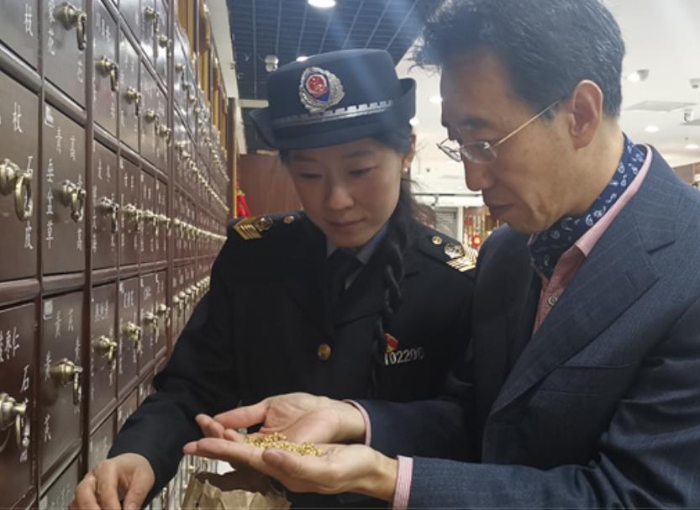 东城区市场监督管理局副局长冯典与监管人员检查中药饮片存储情况 孙彦 摄