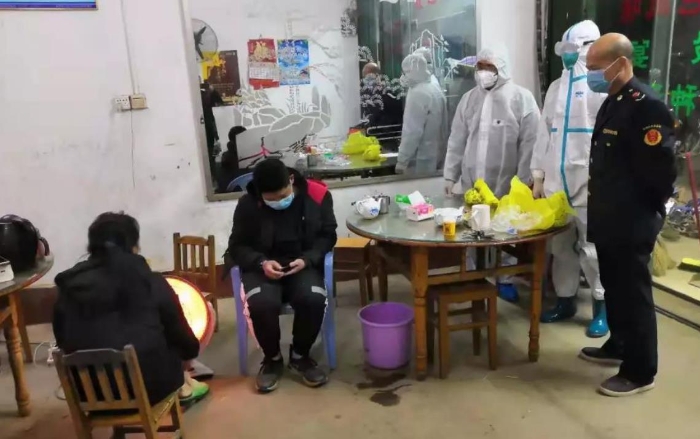 廖斗星（右一）协同卫生院的医护人员到确诊患者就餐过的杨村某酒楼进行排查