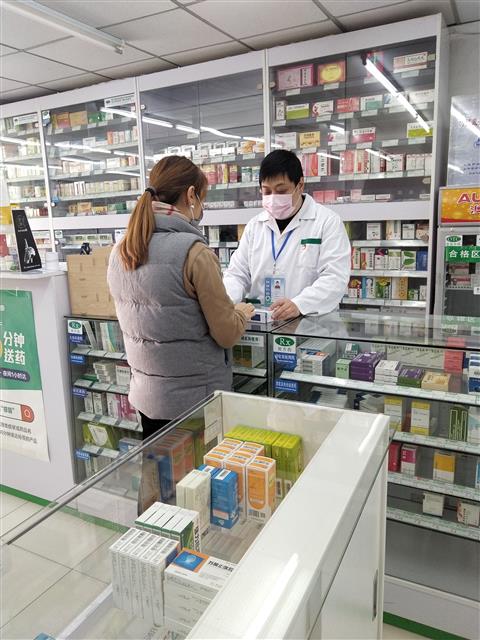 疫情防控时期，魏骏在药店为顾客提供药学服务。