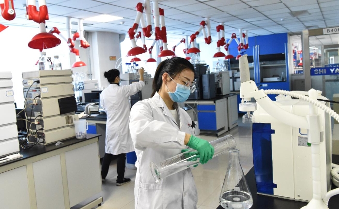 图为吉林省药检所化学室检验人员做盐酸二甲双胍实验。