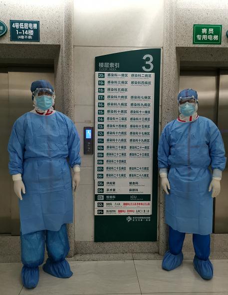 孔立（左）与专家组成员于荣国在武汉一家定点医院巡查。