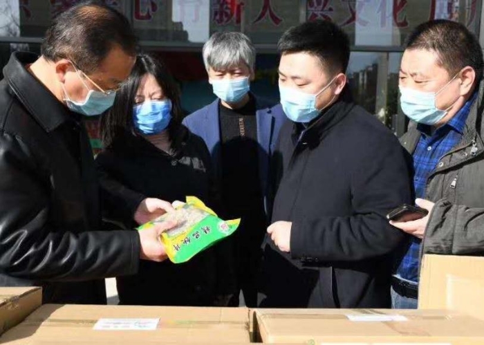 张艳琴（左二）接受企业捐赠抗疫物资。