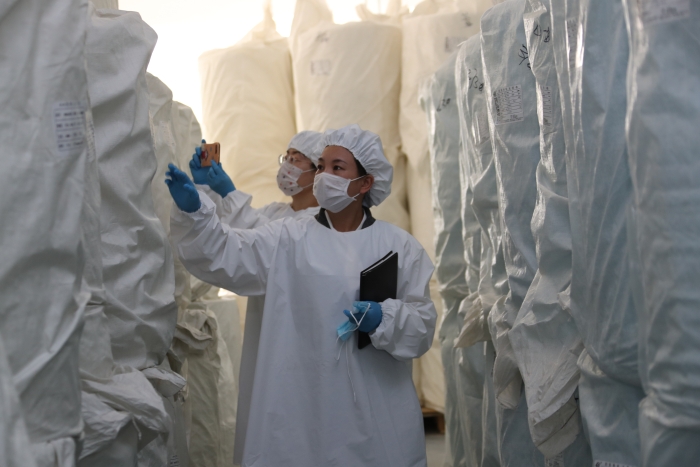 新疆药监局检查组工作人员在医疗器械生产企业检查原材料。
