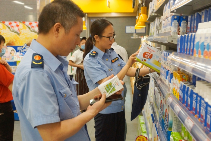 执法人员在一家超市检查乳制品质量