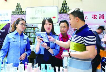 图为甘肃省兰州市城关区市场监管局监管人员为群众讲解化妆品标签知识。丁怡媛　摄