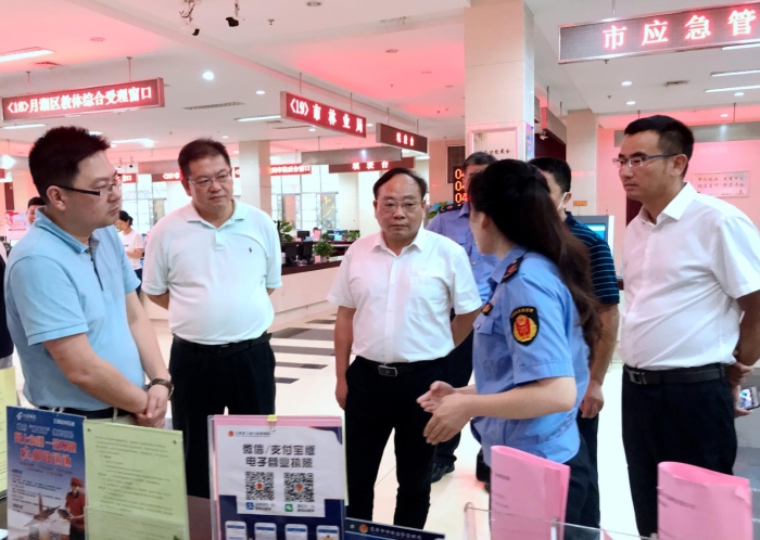 上官新晨（左三）在鹰潭市行政服务中心详细了解“一照含证”改革情况。