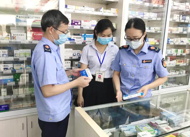 图为该局监管人员在一家零售药店检查药品质量。