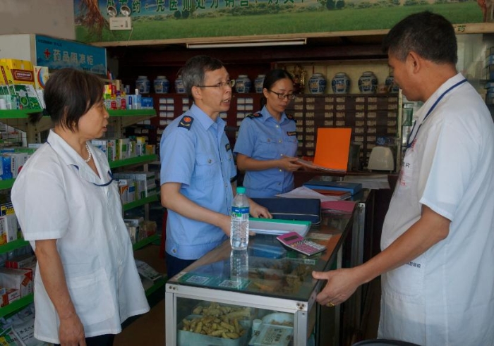 图为该局药械科工作人员对一家换证验收的零售药店进行回访检查。