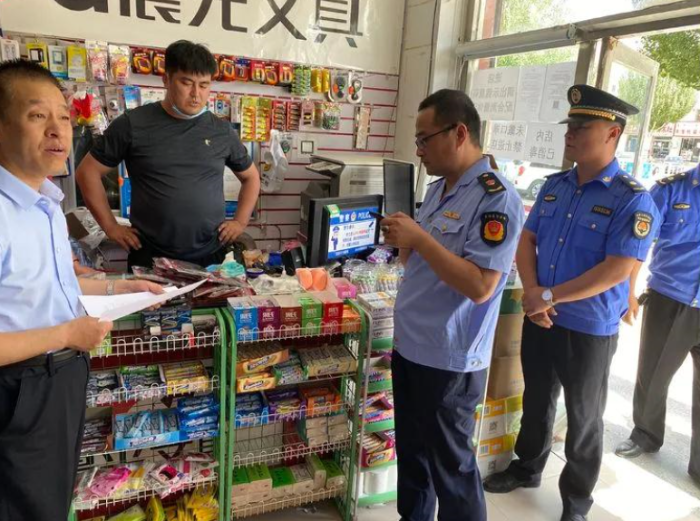 图为该局执法人员在小卖店检查食品安全。