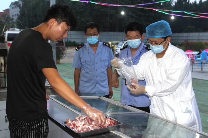 图为近日该局执法人员在县城一夜市烧烤摊点进行羊肉抽检取样。