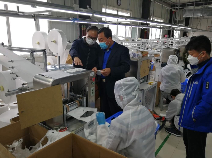 图为延边检查分局局长胡中玉（左二）检查熔喷布生产企业质量安全。