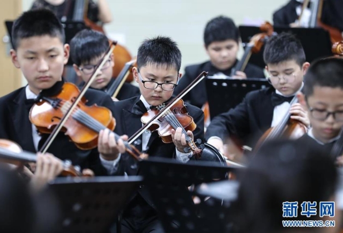 江苏张家港市南丰小学永联校区的管弦乐团在演奏（6月19日摄）。该校80%的学生是外来务工人员的子女，乐团大多由这些孩子组成。 新华社记者 杨磊 摄