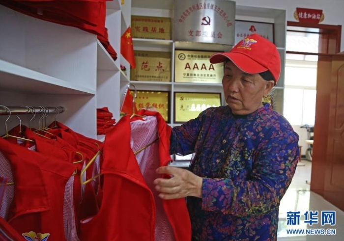 王兰花下班后挂好自己志愿者马甲，结束一天的志愿服务工作（6月23日摄）。新华社记者 贾浩成 摄