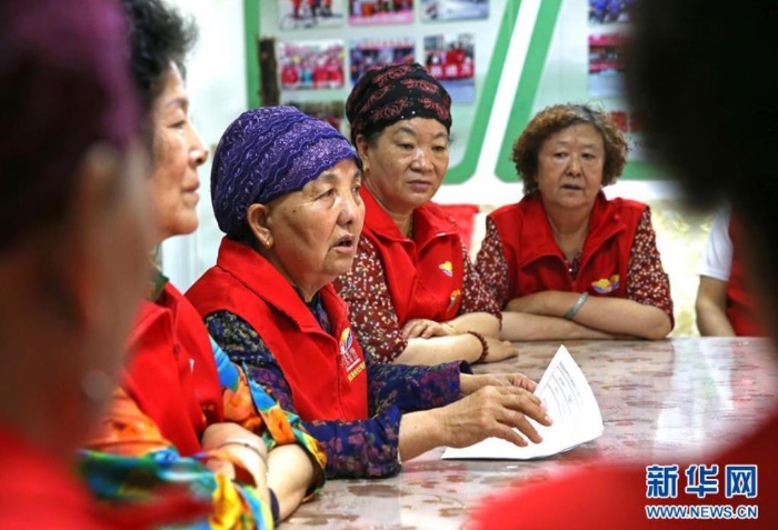 王兰花（左二）与志愿服务队成员一起讨论裕西社区志愿服务工作安排（6月23日摄）。新华社记者 贾浩成 摄