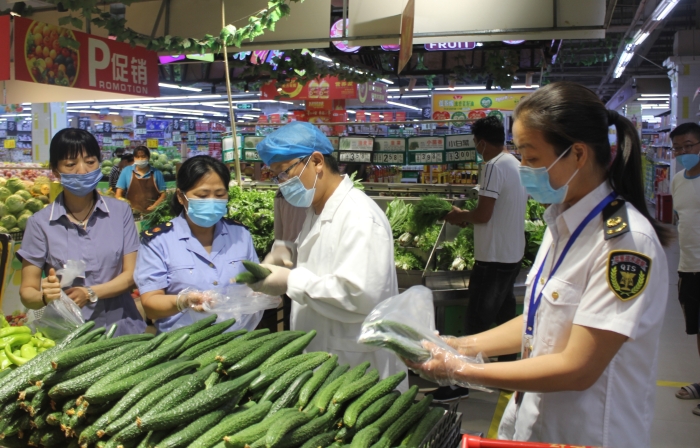 图为该局执法人员会同第三方食品检测机构工作人员在一商场抽样待检。