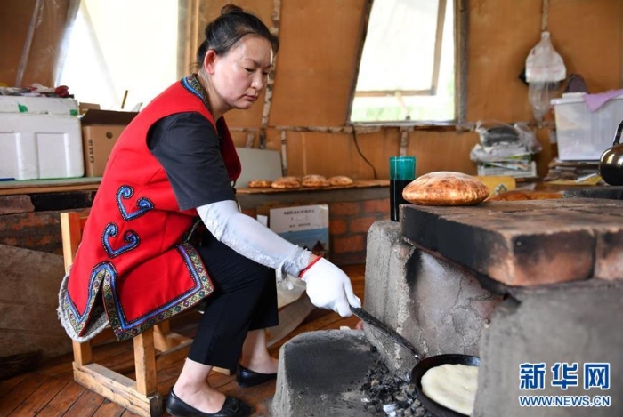 杜峰在位于敖鲁古雅鄂温克族乡的鄂库娜列巴房内烤列巴（7月14日摄）。 新华社记者 贝赫 摄