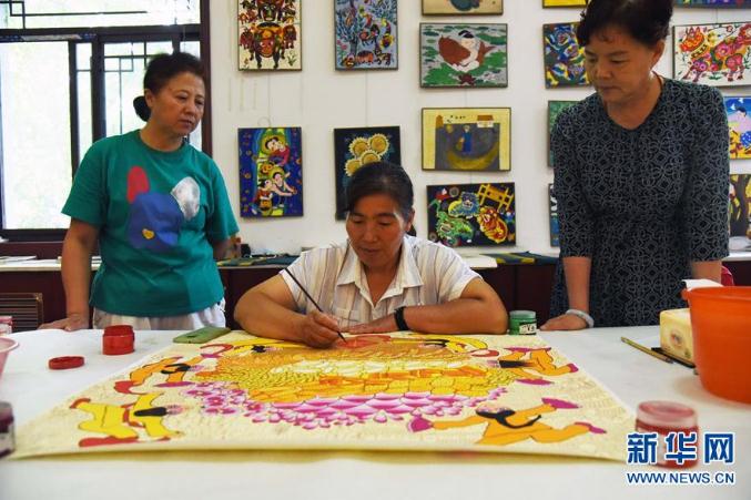 青州农民画画家王化芹（中）在进行创作（7月21日摄）。新华社记者 王凯 摄