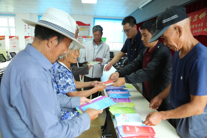 工作人员向村民发放药品安全科普资料。