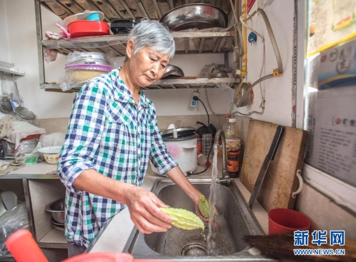 在湖北省保康县马良镇赵家山村，村民在家中用自来水洗菜（8月27日摄）。新华社记者 肖艺九 摄