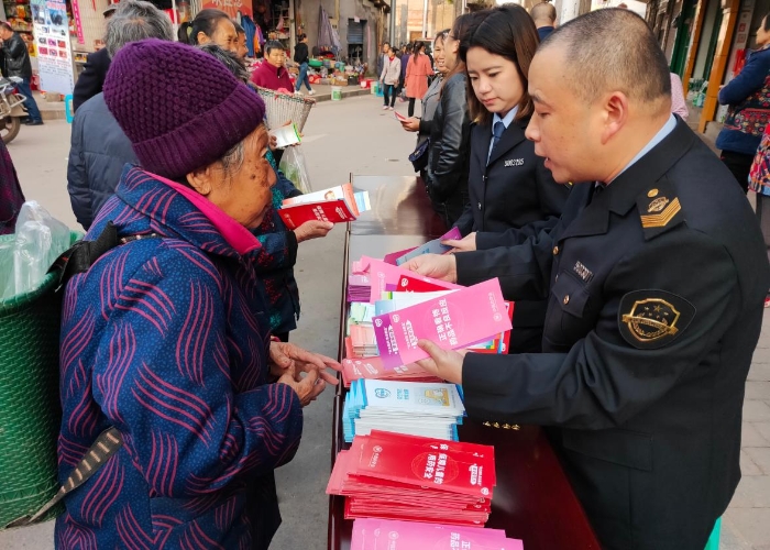 图为11月19日该局百胜镇市场监管所在百胜街头发放宣传资料，现场接受群众咨询