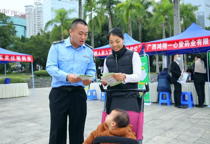 图为南宁市市场监管局工作人员向群众发放安全用药知识宣传手册。（何正君 摄）