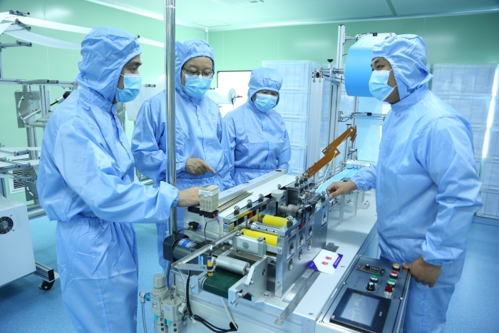 图2为吉林省药监局技术帮扶组指导口罩生产企业提质增效。
