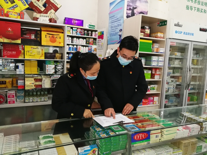 图为鹰潭市市场监管局执法人员正在核对药品零售企业销售发热、止咳等药品的实名登记记录