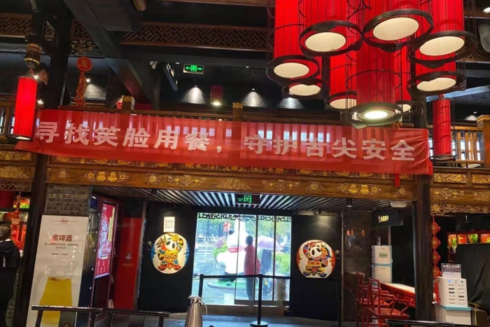 图为各餐饮店悬挂“寻找笑脸餐饮”标语，营造宣传氛围。