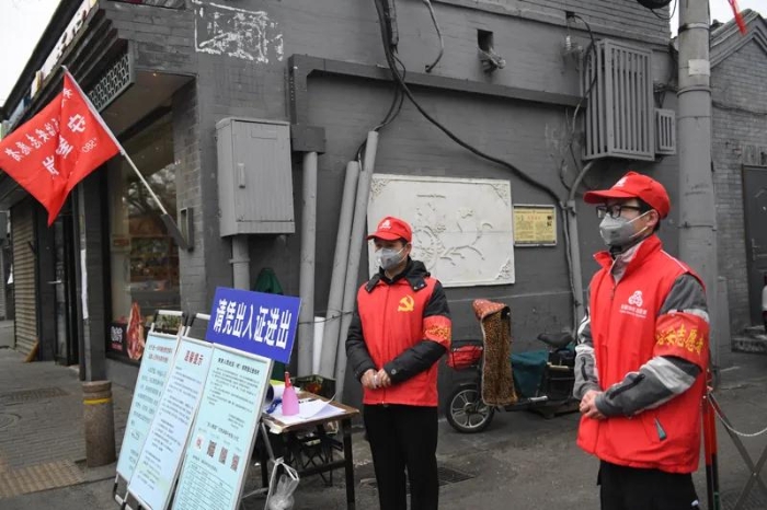 2020年2月27日，志愿者张建国（左）和儿子张洪赫在北京市东城区安定门街道花园社区车辇店胡同口的疫情防控值班点值守。新华社记者 鞠焕宗 摄