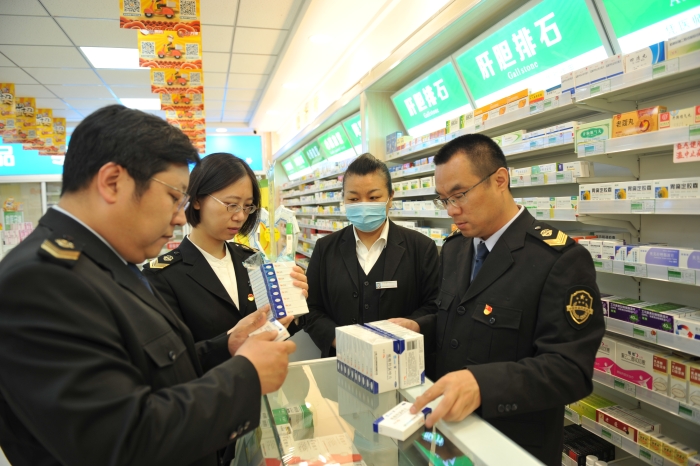 图为该局工作人员在一家药品连锁企业门店进行药品抽检。