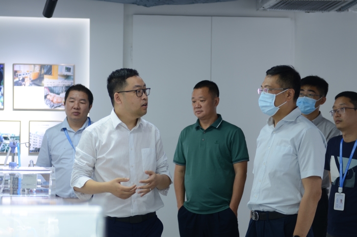 图为器械大湾区分中心副主任徐良（右三）在科曼公司了解产品研发情况。