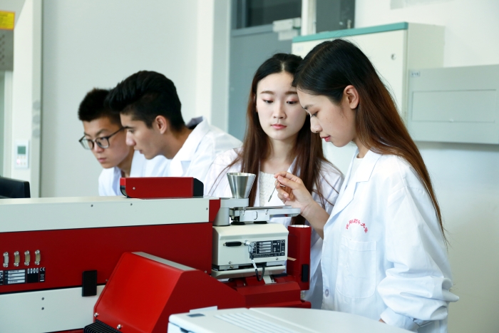 图二为 学校学生在药剂实验教学中心开放实验室进行科研项目实验。