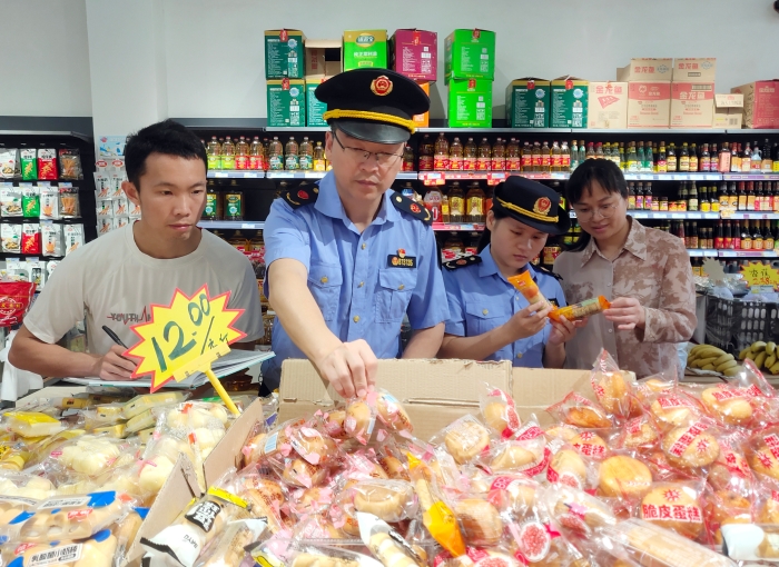 图为5月17日该局执法人员正在一家乡镇超市检查散装食品质量。。
