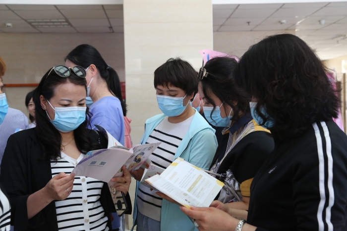 图为社区公众阅读由中国健康传媒集团出版的化妆品科普宣传资料 。