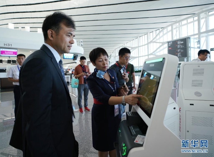 中国东方航空公司工作人员（前左二）在指导乘客通过“人脸识别”办理值机手续（2019年9月25日摄）。新华社记者 鞠焕宗 摄