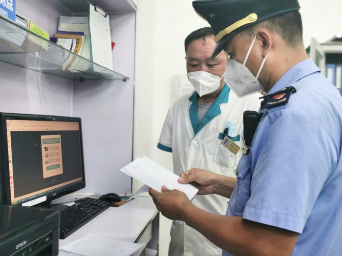 图为昌平区市场监管局执法人员在药店检查疫情防控措施。