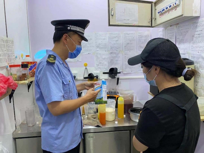 图为顺义区市场监管局执法人员在奶茶店检查。