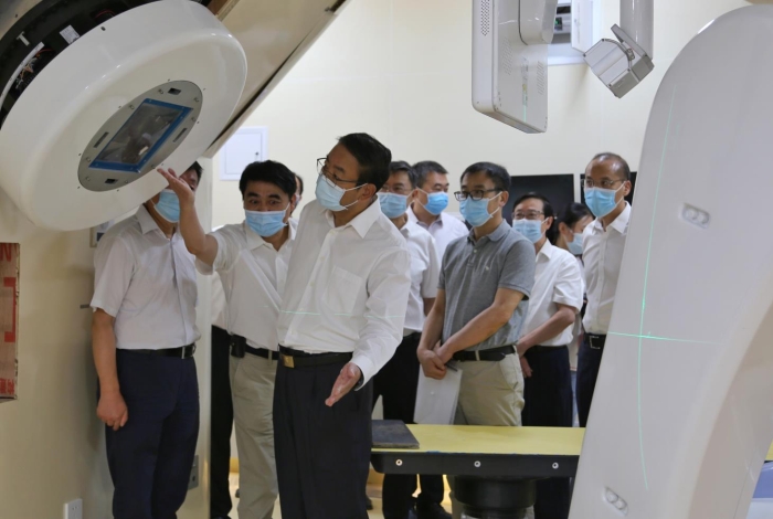 图为张世珍（左三）在兰州重离子医院治疗室查看放射治疗设备。（丁怡媛摄）