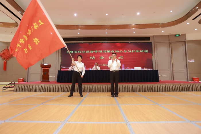 图为上海市药监局党组书记、局长闻大翔为稽查局授旗。