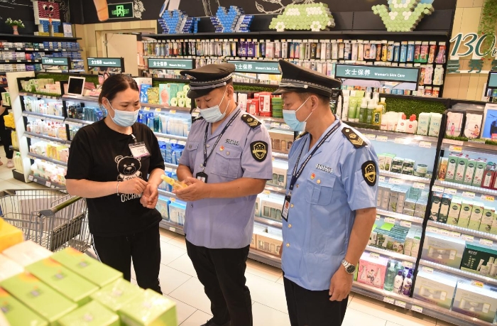 图为河南省开封市市场监管部门执法人员正在超市检查儿童化妆品。